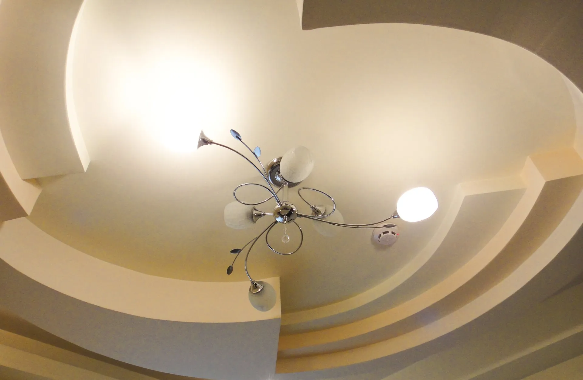 Plafond aux courbes lumineuses avec lustre